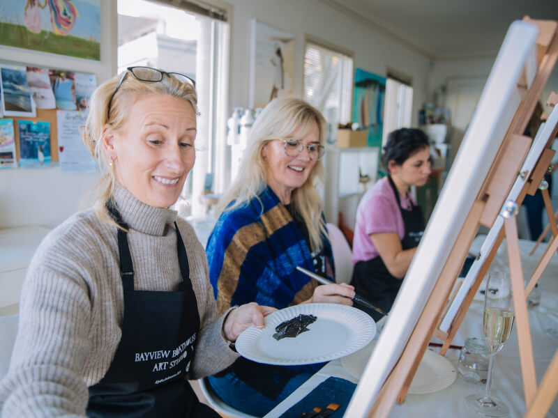 Blond women painting canvases in a studio
